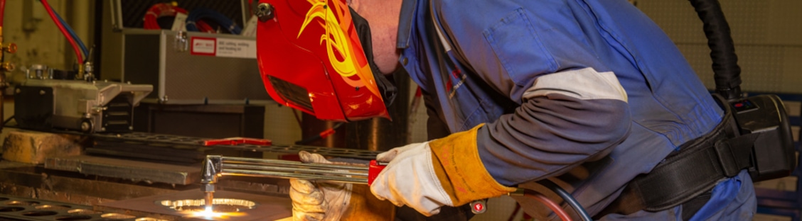 A person wearing a welding mask and gloves A person wearing a welding mask and gloves